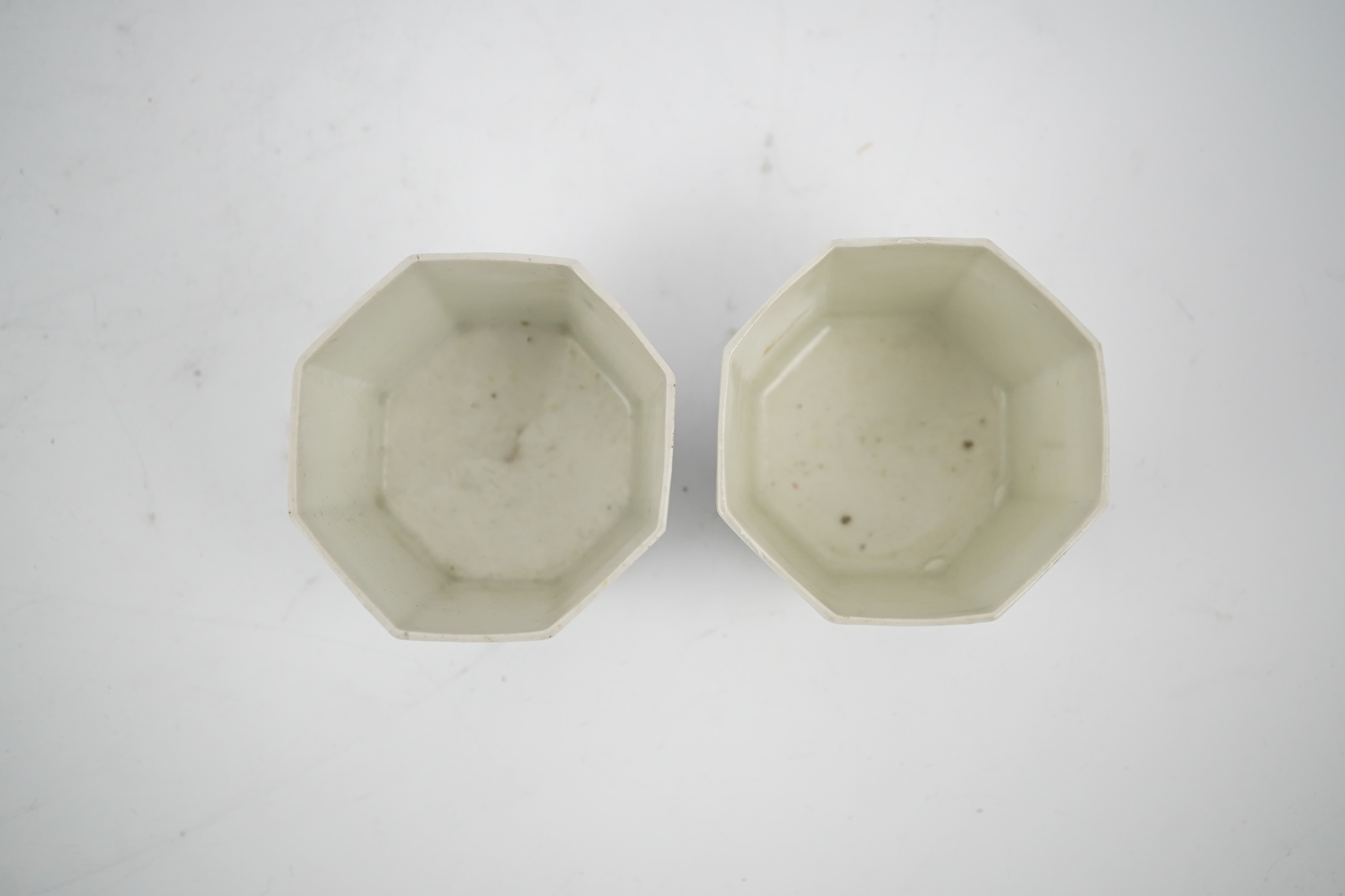 A pair of Japanese kakiemon octagonal porcelain cups, probably Edo period, 5.5cm high. Condition - one restored the other hairline cracks